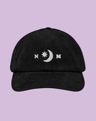 Black North Muse cap with embroidered moon and star logo on lavender background.